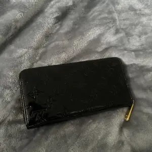 En skinande svart liknande lv plånbok i fint skick och bra kvalitet!