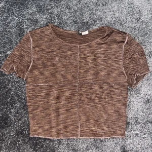 Brun Uniktmönstrad T-shirt - Sömmar som formar ett krys där fram. Är lite cropped men inte överdrivet. Väldigt bekväm och passar till det mesta