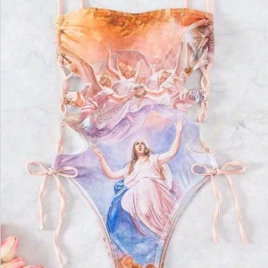 HELT NY & OANVÄND ovanlig baddräkt, pastellfärgad / flerfärgad. Änglar. Strlk: LITEN Large. - HELT NY & OANVÄND ovanlig baddräkt, pastellfärgad / flerfärgad. Änglar. Konst.  Har snörning i sidorna. Högt skuren. Vaddering vid byst. Strlk: Large, dock liten/smal i storleken så skulle säga passar troligen bäst någon med Small-Medium. Helt felfri