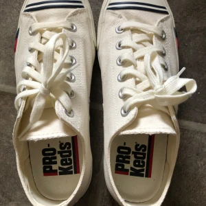 PRO-Keds herr sneakers vit i mycket fint skick - PRO-Keds tyg sneakers vit herr  Storlek 39  Endast använda några få gånger, mycket fint skick. 