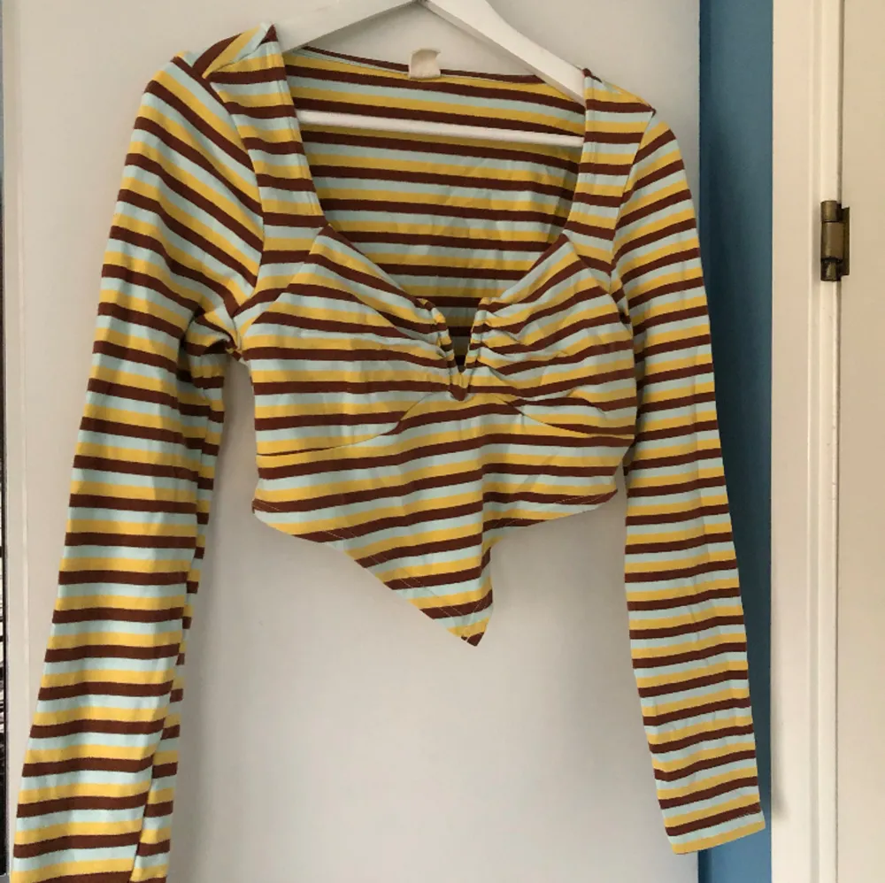 Randig, långärmad tröja med V-shapes från Urban Outfitters 👔Färgerna är ljusblå, brun och gul. Har ej kommit till användning och är i gott skick. Toppar.