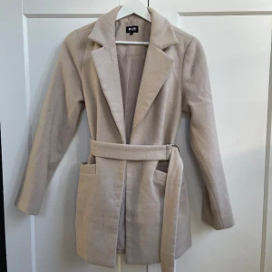 Kappa  - Kappan är i använt skick den har en smutsfläck under ena framfickan. Går säkert bort i tvätten.