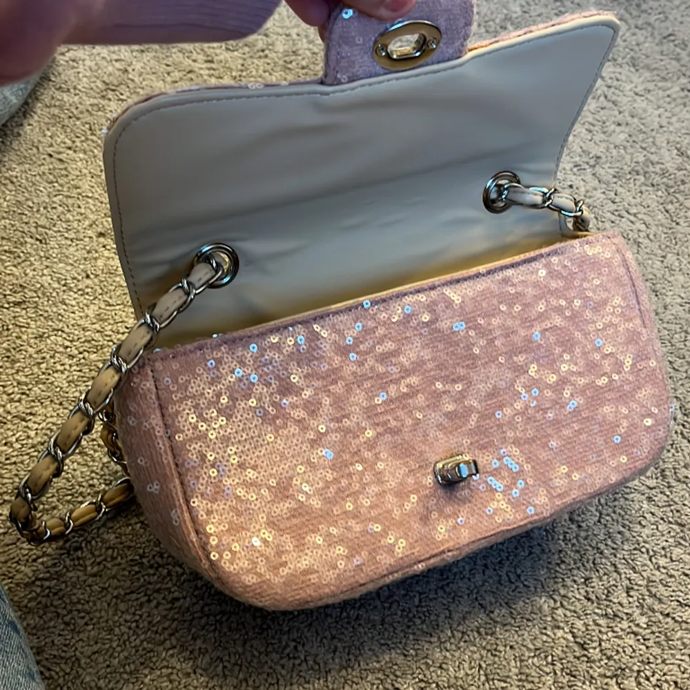 Fin väska från Gina Tricot som har glitter paljetter och den e rosa med silver kedja runt om de beiga banden!💕❤️. Väskor.