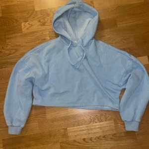 Blå långärmad kort hoodie - En kortare nästan magtröjs hoodie i blå färg. Super snygg i storlek XXS men den passar XS/S.