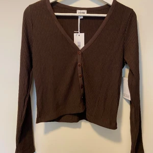 Brun tröja - OANVÄND med lappar! Brun mysig tröja med knappar från Bubbleroom. Väldigt fin men aldrig använd så tycker den förtjänar bo in sig hos någon annan☺️