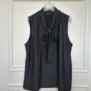 Svart blus med knytning/rosett - Snygg svart topp med glitter och band runt halsen som man knyter väldigt snyggt som rosett🎀 endast använd 2 gånger🌟