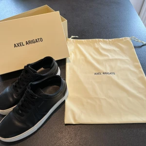 Axel Arigato Platform Sneakers i stl 38 - Sneakers från Axel Arigato, modell Platform. I mycket bra använt skick. Originalkartong och skopåse följer med i köpet.  Storlek: 38 Färg: Svart med vit sula  Material: Skinn Nypris: 2450 SEK 