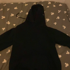 Marinblå hoodie med luva på - Den ser svart ut på bilden men är egentligen marinblå