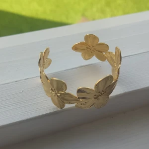 Guldfärgat armband med blommor - jättefint armband med blommor. storleken går att justera. säljer då jag har för mycket smycken. Helt oanvänd, bara testad 