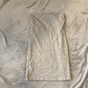 Tajt klänning  - En grå klänning som har extra lager vid bysten