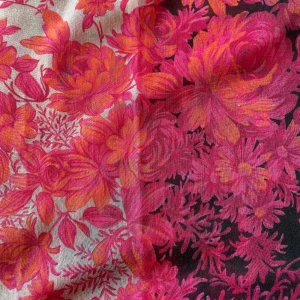 Blommig halsduk - En vacker halsduk med ett blommigt mönster i rosa och orange nyanser på en vit och svart bakgrund. Halsduken är mjuk och bekväm.