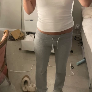 Grå mjukisbyxor - Ett par grå mjukisbyxor i storlek medium för dam. Byxorna har en dragsko i midjan för justerbar passform och är tillverkade i ett mjukt och bekvämt material.