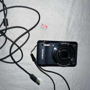 Digitalkamera Samsung - Liten digitalkamera från Samsung, modell WB35F i gott skick. Skärmen har lite repor.  12x optisk zoom  Kameran ska ha inbyggt WiFi men har inte testat det på ett tag. 
