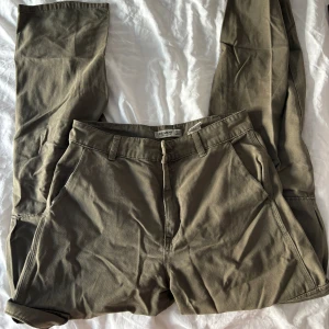Gröna Cargos - Gröna cargobyxor från Pull&Bear storlek 38. Säljer pga kommer inte till användning. Kom privat för mått eller mer bilder!