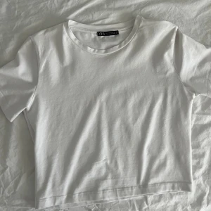 Vit t-shirt/croptop - Vit kort t-shirt från zara i storlek S som aldrig använts. Vit vanlig mer äggvitsfärg och i bomull/vanligt t-shirt tyg. Skön o stretchigt material❤️