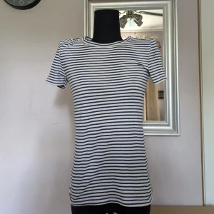 Randig kortärmad tröja - Den e i bra skick. Använd ett fåtal gånger. Inga tecken på att vara sliten. 