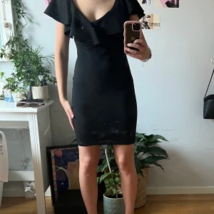 Festklänning  - Svart festklänning med volanger från Nelly One som är köpt secondhand men som jag aldrig har använt då klänningen är för stor i bysten