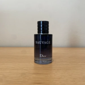 Dior sauvage eau du toilette - En Frisk, maskulin, och kryddig doft som kombinerar fräscha citrusnoter med träiga och ambra toner, vilket gör den perfekt för både dag och natt, året runt!  Förvarats från solljus och i jämn temperatur. 25ml/60ml kvar. Nypris 950kr Mitt pris 189kr