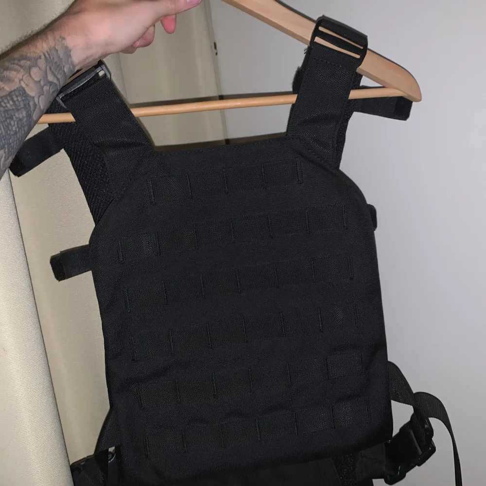 ”Tactical” väst som ser ut som en skyddsväst.  Perfekt för träning eller som ett fashion statement Svart / black. Fraktas med Postnord över hela Sverige eller hämtas på plats.. Sportswear.