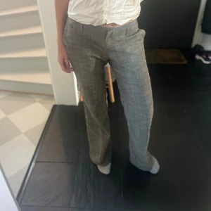 Gråa kostymbyxor - Säljer ett par gråa lågmidjade kostymbyxor. Jag är 173 cm och byxorna går ner hela vägen. Frakt tillkommer!