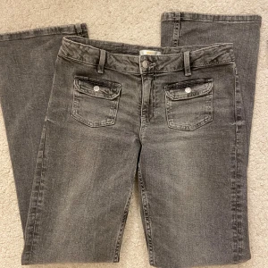 Low Bootcut jeans  - Super fina jeans från Young Gina, köpta för 350 men säljer för 200! Använda fåtal gånger💛 Fina gråa lågmidjade och justerbara jeans💕de har alltså knappar i midjan som går att justera storleken på midjans byxor! Är 167 cm lång!