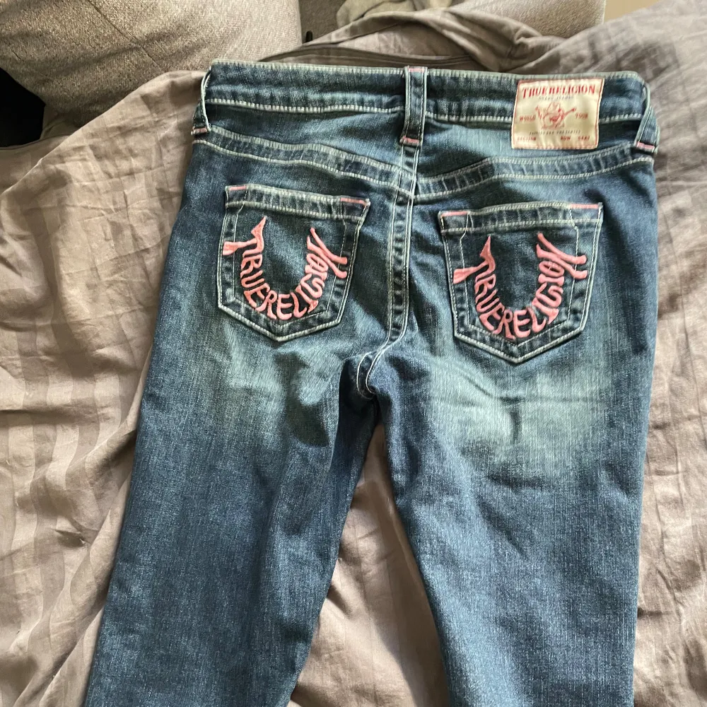 Skitsnygga jeans från true religion med rosa detaljer, helt nya endast testade och köpta för 1600. Innebenslängden är ca 79 cm och midjemåttet 37💞. Jeans & Byxor.