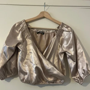 Satintopp - Satintopp i storlek S. Aldrig använd. Färg: guld/beige.