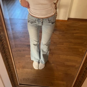 Lågmidjade bootcut jeans  - Lågmidjade bootcut jeans med coola bakfickor. Har ett hål på framsidan men inget som syns när man har de på sig. Midjemått 34 cm, innerbenslängd 74 cm. Tryck på köp nu om du vill köpa ❤️‍🔥