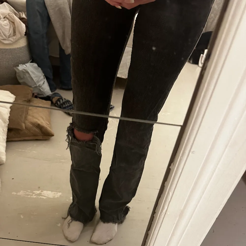 Mörkgråa Midwaist jeans ifrån Gina Tricot med hål i benet och slitningar nere vid fötterna. Säljer då de är för små. . Jeans & Byxor.