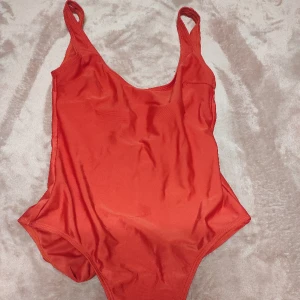 Röd badräkt - Ny. Aldrig använd .  Hög ben skuren. Passar en S. 