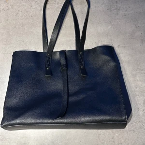 Väska - Jättefin svart väska från Mango! Den är lite använd men funkar som vanligt! Rymmer jättemycket och är väldigt praktisk!! Mått: 39cm (längd) x 28cm (höjd) x 17cm (bredd)