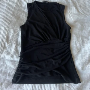 Svart topp - Unik svart topp som sitter mycket snyggt, ser oanvänd ut