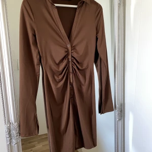Brun klänning - Brun klänning från Nellys egna märke. Materialet känns nästan lite som träningsmaterial, mycket skönt 