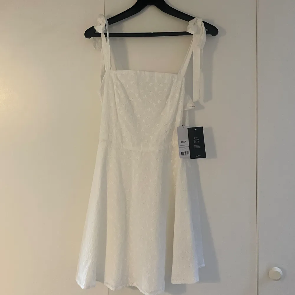 Helt oanvänd vit kortklänning köpt på NAKD. Lappar finns kvar, storlek 34/XS. Köpt för 399kr, sista bilden är från hemsidan ✨ Söta blomdetaljer. Perfekt studentklänning. Kan mötas upp i leksand eller fraktkostnad tillkommer 🫶🏼 Swish. Klänningar.