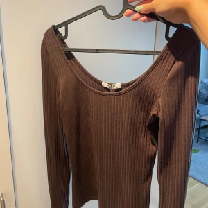 Brun topp - Brun åtsittande långärmad topp. Använd men i fint skick.