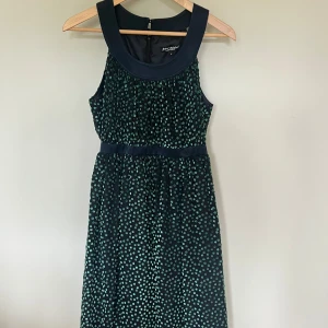 Klänning Betsey Johnson  - Fin klänning från Betsey Johnson. Mörkblå i botten med gröna prickar.  Använd 2 gånger. Storlek 36/38. 
