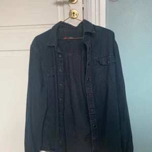 Svart jeansskjorta Dressmann - Svart jeansskjortja från Dressman i storlek L  Bra skick, använd endast lite grann. Fråga gärna om du har några frågor😊