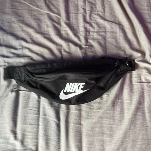 Nike väska  - En svart nike väska ”beknarväska” som jag nästan inte använt den är bra och har 2 olika fickor med en mindre ficka inuti. köpt för 250
