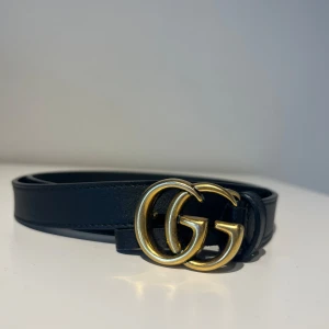 Bälte Gucci - Svart läderbälte med guldspänne. Endast använt ett fåtal gånger. Storlek 70.