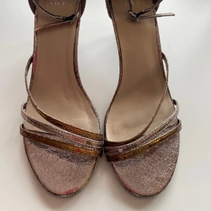 Klackskor - Säljer dessa klackar i storlek 39. Använda 2 ggr. I en metallic färg av lila och brons. 