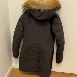 Parajumper vinter jacka  - Simpel parajumperjacka i en fin mörkgrön/brun färg med äkta avtagbar päls och en avtagbar fluffig del runt nacken. Använt den en och en halv vinter. Köpt en ny jacka och vill därför sälja denna! 