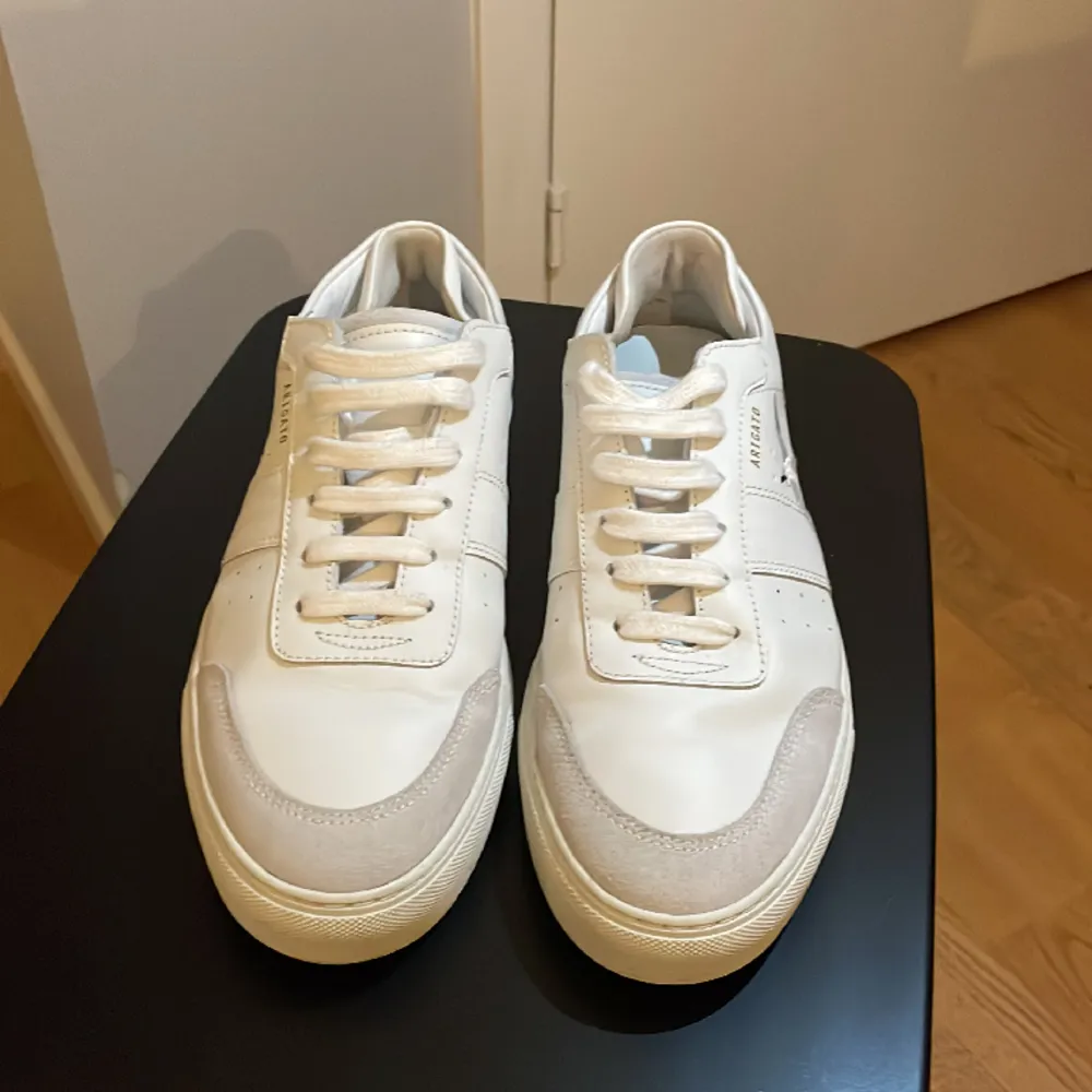 Ett par snygga, vita sneakers från arigato. Nyskick, använda 2 gånger. Storlek 43. Nypris 2650 kr, säljes för 1250 kr.. Skor.