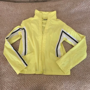 Nike jacka gul träningsmodell - Gul Nike jacka, träningsjacka Nike med dragkedja. I gott skick förutom en knappt synlig fläck på baksidan, se sista fotot