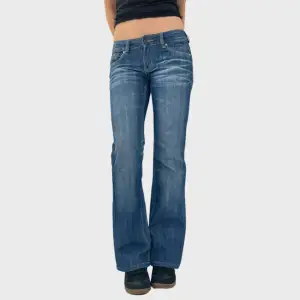 38. Lågmidjade bootcut jeans   Midja: 37 cm Innerbenslängd: 77 cm  Modellen är 172 cm lång och bär vanligtvis 34/36  