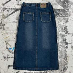Vintage jeanskjol med fina detaljer på fickor och sidorna. Midjemått 79 cm, kjolens längd 90 cm