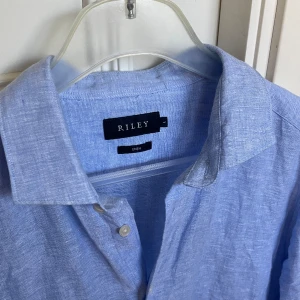 Blå Linneskjorta - Riley - Tja! Säljer nu denna linneskjorta från Riley. Storlek: L. Skick: 9/10. Nypris: 900kr. Modellen är 186 och väger 79kg. Kontakta oss för fler bilder eller info!