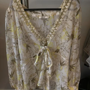 Blus  - Fin blus med knytdetalj både framtill och nere på ärmarna. Väldigt lite använd och superfint skick.