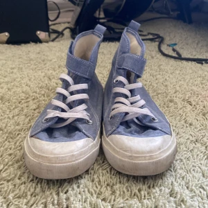 Converse strl 33 - Säljer nu ett par gamla höga Converse med kardborre i storlek 33. Högra skon har en liten fläck på bakre sidan men inget som märks. De passar jättebra som sommar/vår skor och är super bekväma! 