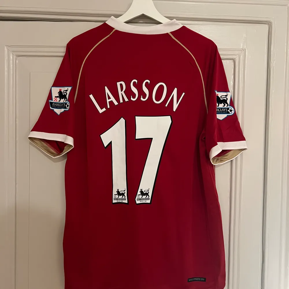 En reprint av Henrik Larssons matchtröja från hans tid i Manchester United under 2007. Henrik Larsson stod för ett krigande av vilja och löpningar som bidragande till att Manchester United vinner ligan denna säsong! Storlek L. T-shirts.