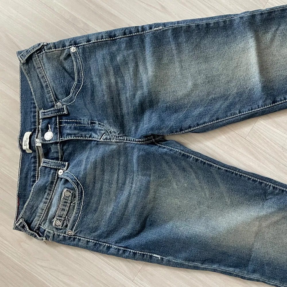 Feta true religion jeans i modellen Ricki köpt på urban outfitters! Jeansen är i nyskick men har små slits längre ner så dem får en mer ”baggy” look gjort av mig 🤗. Storlek 28, skriv för mer bilder och mått! 🌟. Jeans & Byxor.